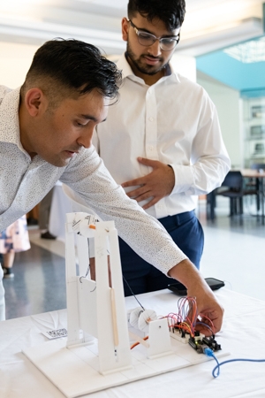 Two researchers working with a prototype including a circuit.